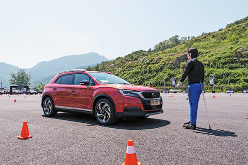 A Changan DS 6 model demonstrates an advanced driver assistant system that helps the car brake to stop in front of a dummy in September in Shenzhen, Guangdong Province. (Photo by Hao Yan/China Daily)