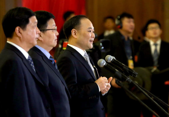 Li Shufu (center), chairman of Zhejiang Geely Holding Group, answers reporters' queries before the closing meeting of the First Session of the 13th NPC on March 20, 2018.(Photo by Wang Zhuangfei/China Daily)