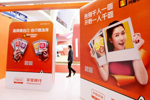 A visitor walks past a booth of Ping An Insurance at an international financial exhibition held in Beijing. （Photo by Lei Kesi/for China Dail）