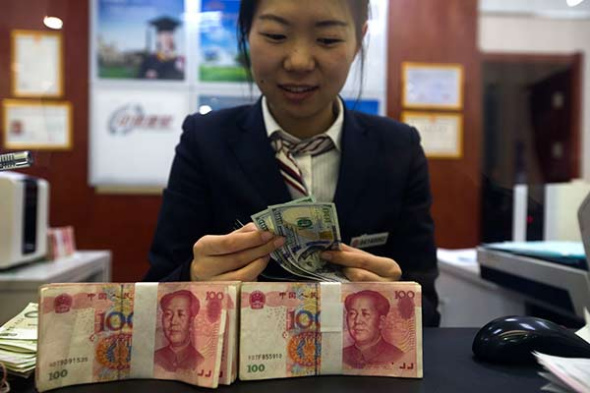 A clerk counts cash at a bank in Taiyuan, capital of Shanxi province. (Photo: China News Service/Zhang Yun)