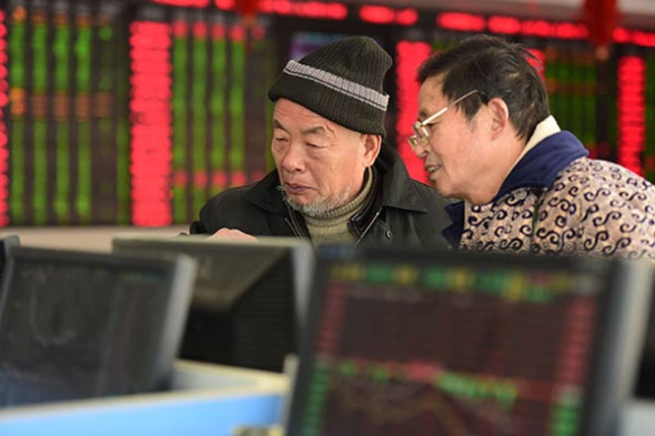 Retail investors check share prices at a securities brokerage in Fuyang, East China's Anhui province. (Photo by An Xin/for China Daily)