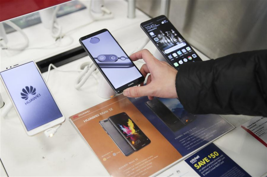 A man tries a mobile phone made in China at a Best Buy store in New York, the United States, on March 22, 2018. (Xinhua/Wang Ying)