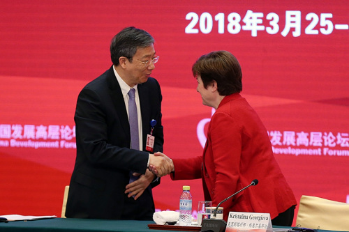 Yi Gang, newly elected governor of the People's Bank of China, greets Kristalina Georgieva, chief executive officer of the World Bank, at the China Development Forum 2018 in Beijing on Sunday. (Photo/CHINA DAILY)