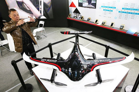A visitor takes photographs of an SF logistics drone at a high-tech exhibition in Nantong, Jiangsu province. The company is stepping up efforts to build a drone network.(Photo by Xu Congjun/for China Daily)