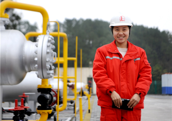 Mi Ying poses for a photo near gas production equipment on Sinopec's Fuling shale gas field, Southwest China's Chongqing. (Photo provided to chinadaily.com.cn)