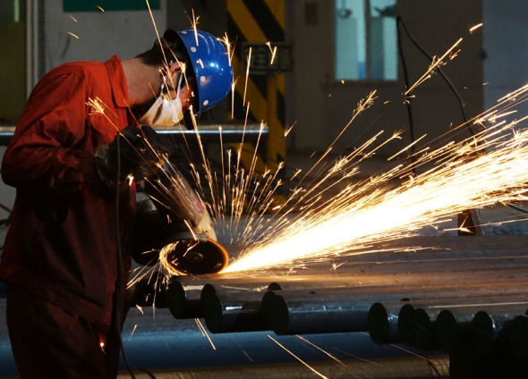 An employee polishes the surface of steel products at Dongbei Special Steel Group Co Ltd in Dalian, Liaoning province. (Photo by Liu Debin/For China Daily)