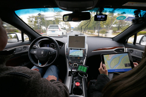 Two people in Guangzhou, Guangdong Province, test an autonomous car on Jan. 31. (Photo: FU TIAN/CHINA NEWS SERVICE)