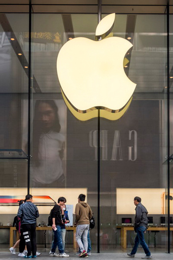 Customers look at products in an Apple flagship store on Nanjing Road in Shanghai. iPhone products include components made in different countries around the world and are only assembled and manufactured in China. But the calculation of trade statistics attributes most of the value to China. (Photo provided to China Daily)