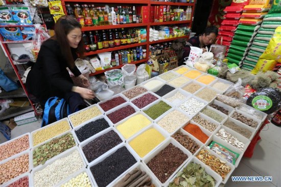 A grocer sells grains at a market in Nantong City of east China's Jiangsu Province, April 11, 2018. (Xinhua/Xu Congjun)