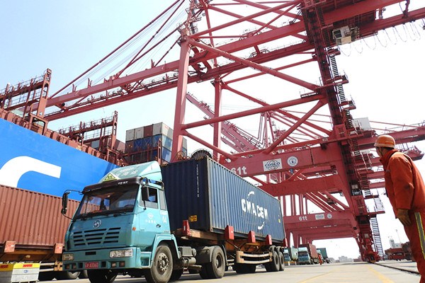 A harbor employee oversees cargo unloading in Lianyungang Port, Jiangsu Province. (Photo/for China Daily)