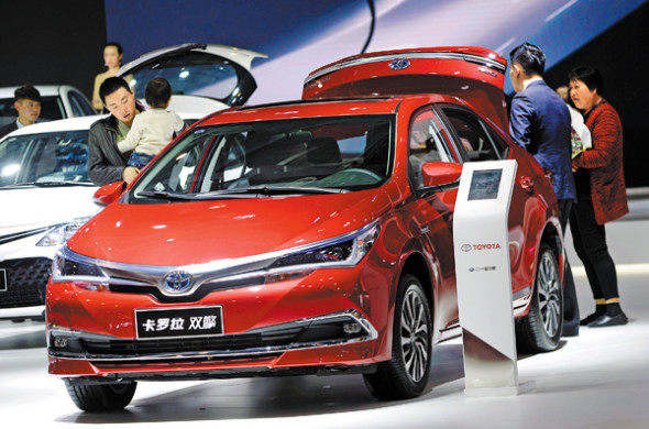 A Toyota Corolla twin-engine hybrid sedan attracts attention at an auto show in Hangzhou, Zhejiang province. (Photo for China Daily/Shi Jianxue)