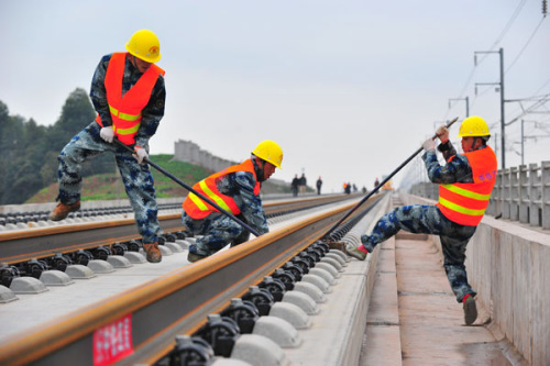 Workers from China Railway Construction Group lay tracks along the Chengdu-Guiyang high-speed railway line. (Photo by Cao Ning/For China Daily)