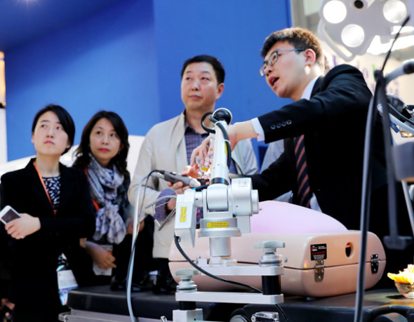 A technician shows how to use 3D medical equipment during an industry expo earlier this month in Shanghai. (Photo/Xinhua)