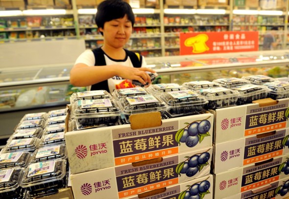 A customer picks a box of blueberries at a supermarket in Zhengzhou, Henan province.(Photo for China Daily /Sha Lang)