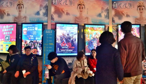 Moviegoers read film synopses on a wall display at a cinema in Nankai district, Tianjin. China's entertainment industry will see customized insurance products. (Photo provided to China Daily)