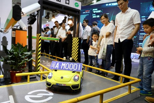 Visitors look at a model of an automated expressway toll-charge system at the first Digital China Summit in Fuzhou, Fujian Province. (Photo by Zhu Xingxin/China Daily)