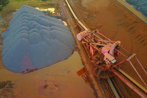 Imported iron ore is stored at a yard in Nantong, Jiangsu province.(Photo by Xu Congjun/China Daily)