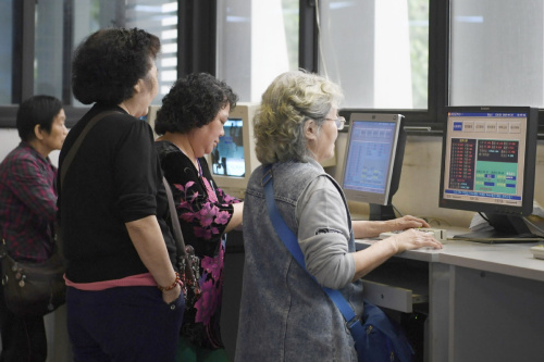 Investors check stock quotes at a brokerage in Chengdu, Sichuan Province, on April 24. (Photo/China News Service)