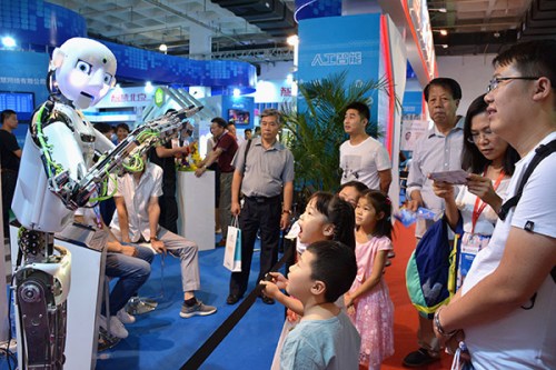 Delighted children and adults watch the performance of a robot at the 2017 China Beijing International High-Tech Expo on June 8. (Photo/China Daily)