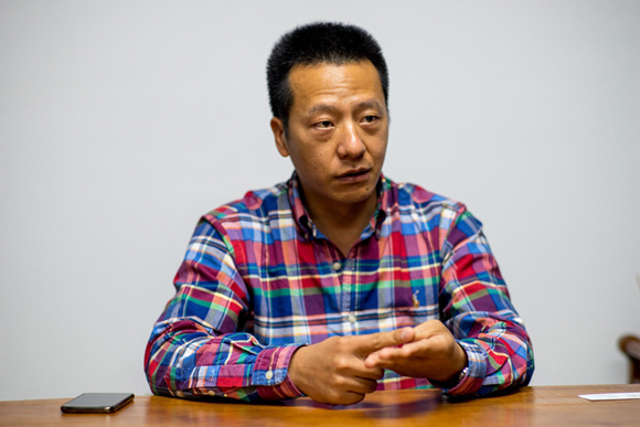 Wang Minfeng sits in his tools store in Yiwu on April 24, 2018. (Photo/China.org.cn)