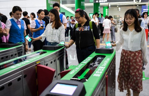 Passengers scan QR codes on their smartphone screens to pay for their subway train ride in Shenzhen, in southern Guangdong province, on May 8, the day when mobile payments were expanded to cover the entire subway network. (Photo/Xinhua)