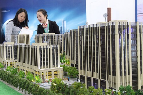 A salesperson presents a housing project at a real property exhibition in Beijing. (Photo provided to China Daily)
