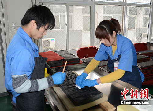 Two workers are cleaning Canon boards.