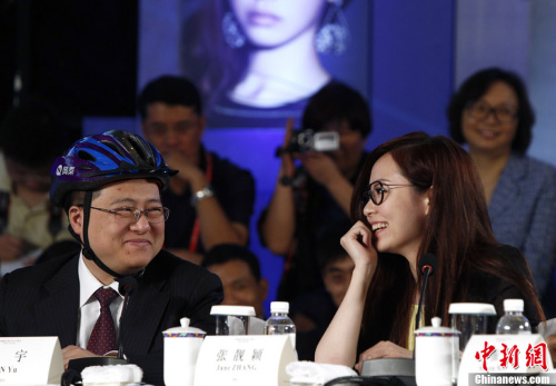 Lin Yu (L), CEO of NetQin, a Chinese mobile-security firm, who wears a safety helmet to the discussion.