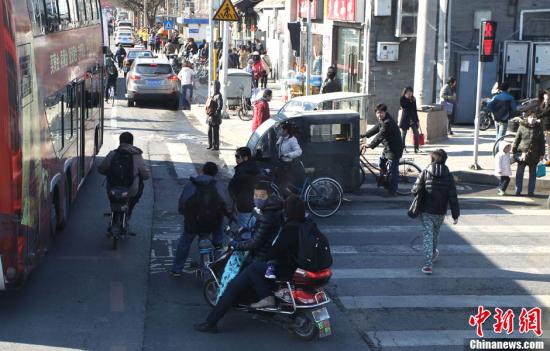 Pedestrians jaywalk on a street in Beijing on Wednesday. (CNS PHOTO/Guo Junfeng  
