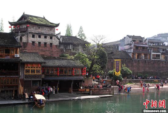 Tourists queue at an entrance in Fenghuang town, Hunan province, April 10, 2013. The town began charging for visits on Wednesday.  (CNS/Tian Rujun)