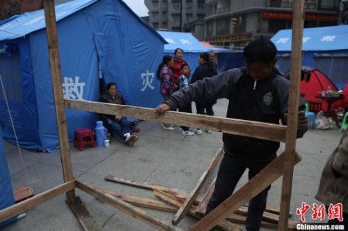 A man is setting up a makeshift tent in Baoxing county, Sichuan province, April 21, 2013. (CNS Photo) 