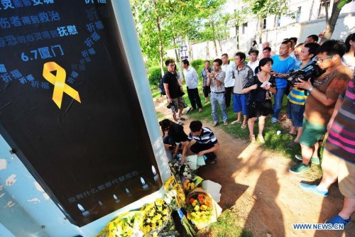 People lays flowers to mourn for the victims in front a pier of the elevated bus lane where a bus fire took place on Friday, in Xiamen, southeast China's Fujian Province, June 8, 2013. The bus fire has claimed 47 lives and hospitalized 34 passgengers. (Xinhua/Wei Peiquan) 