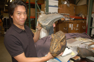 Fong Sam shows a basketball-sized model of a dinosaur head used in Jurassic Park. [Photo:World Journal(US)/Chen Guangli]