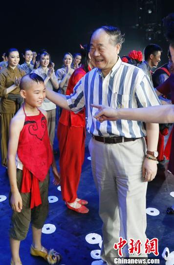 Mo Yan meets actors after Qingdao Song & Dance Theatre put on the second performance of Red Sorghum on Sunday night.[Chinanews.com]
