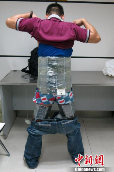 A smuggler shows the smartphones attached to his body. Shenzhen Customs detained five smugglers from Hong Kong on Tuesday and seized 330 smuggled cellphones worth one million yuan (US$163,370). (CNS photo)