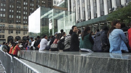 Chinese wait in lines outside the Apple Store on New York's Fifth Avenue to purchase the new iPhone 5S. (Photo: World Journal)