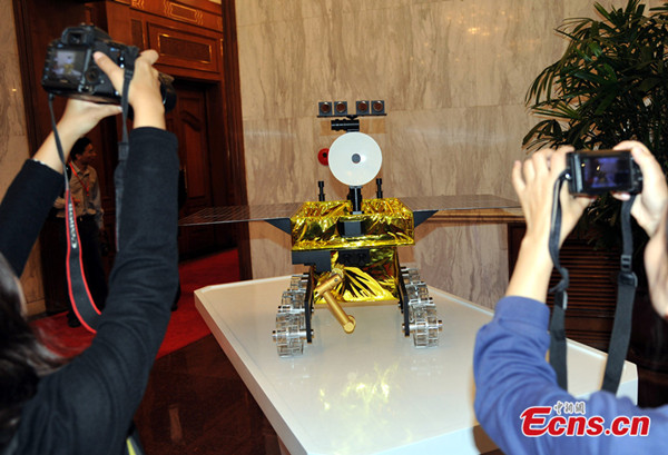 Visitors take photos of a 1: 2 scale model of Chang'e 3 moon rover on September 25, 2013. A public naming campaign was launched for the moon rover on the same day in Beijing which will be lunched by the year end. [Photo: China News Service / Sun Zifa]