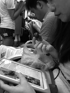 A photo taken by Zhu Qian shows that the middle-age woman eats grapes on subaway.