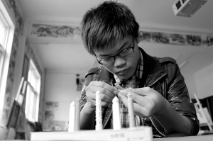 Bai Shengming, 18, makes chalk carvings carefully.