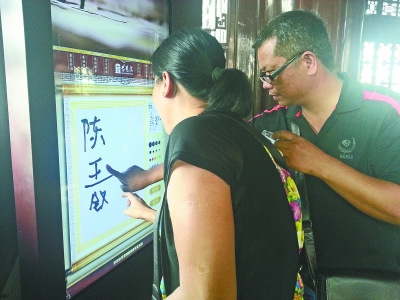 A couple leave names on the touchscreen at the Yellow Crane Tower. (Photo source: whwb.cjn.cn) 