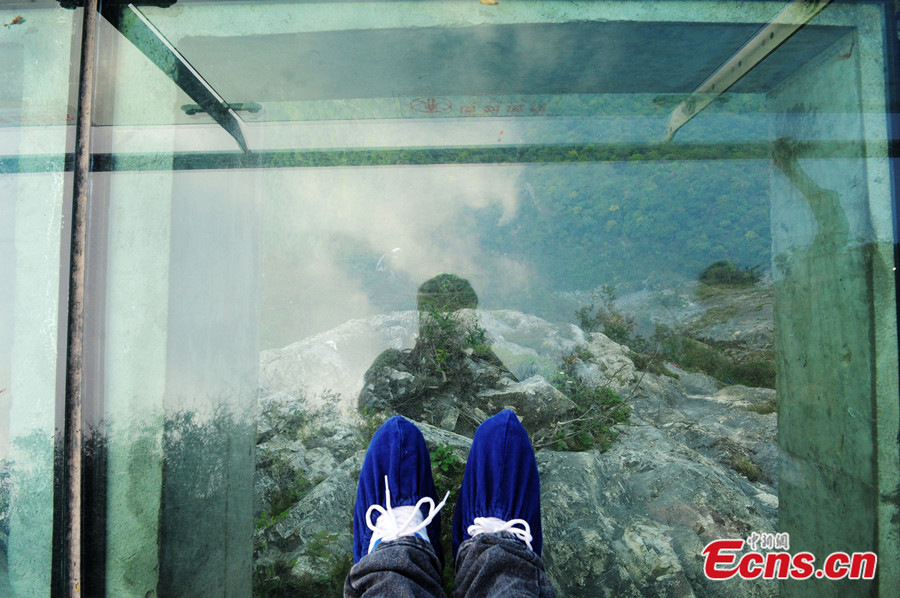 Photo taken on October 13, 2013 shows a glass plank road at Tianmenshan National Forest Park of Zhangjiajie in Hunan province. The glass plank road is about 60 meters long and 1430 meters above the sea level. [Photo: China News Service / Yang Huafeng]