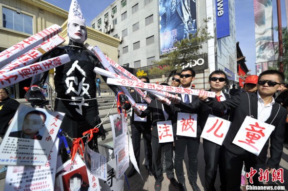 College students call for greater anti-trafficking awareness and harsher crackdown on child trafficking through street art performance in Taiyuan, capital city of north China's Shanxi province on October 20, 2013. [Photo: China News Service / Wei Liang]