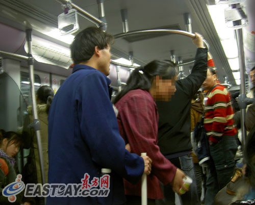 Two beggars ask passengers on a subway for money. (Photo source: east.com)