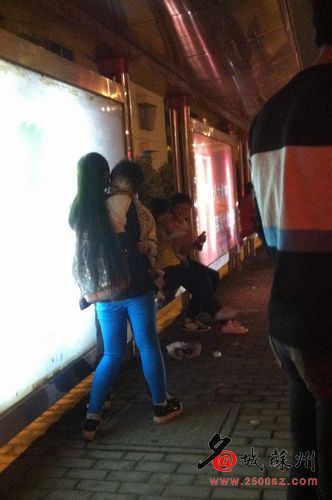 The boy held the girl in his arms, whispering in her ear.