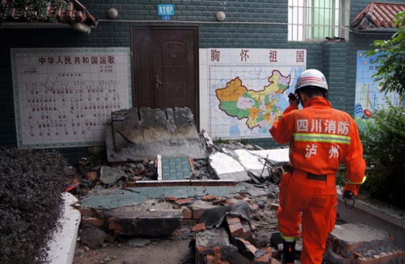 A firefighter examines the debris of a collapsed wall that killed three students and injured six others at a school in Luzhou, Sichuan province, on Wednesday. Zhou Weinan / For China Daily