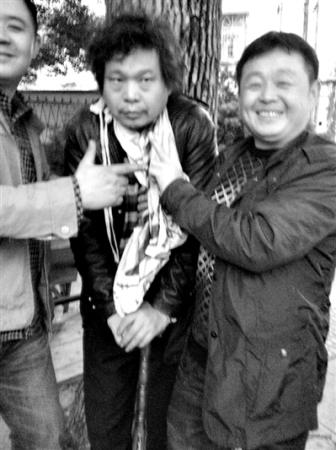In one of the photos taken on November 11, 2013, Duan is hunched forward like a prisoner with two smiling officials beside him, one of whom is giving a V-sign.