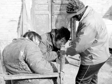 Photo taken by a local nespaper shows Wu and her paralyzed twins.