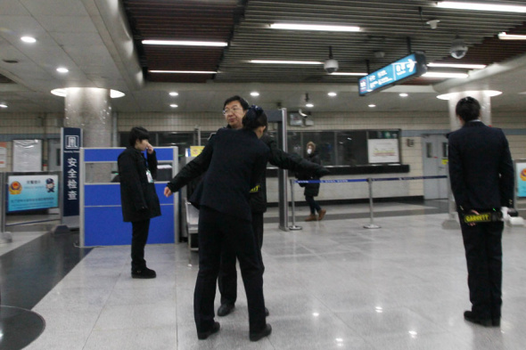 A man is checked by security at the Tian'anmen East Station, in Beijing, Dec 16, 2013. The capital has so far added metal detectors at two of its subway stations - Tian'anmen East and Tian'anmen West C and will later install them at another three subway stations. [Photo by Wang Yueling/Asianewsphoto]