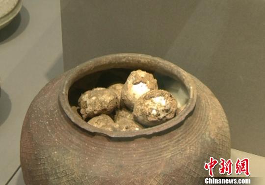 An old pot containing dirt-covered fossilized eggs dating back to the Western Zhou Dynasty (1046BC-771BC) is on display at the Nanjing Museum in Nanjing, East China's Jiangsu province. [Photo: Ge Yong]