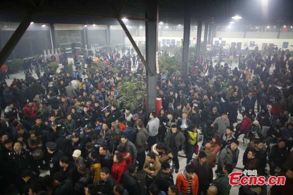 Local residents stand in line waiting to proceed with transactions of car sales in a used car market in Tianjin on Dec 15, 2013, a day before the city began imposing quota on its new car plates. The city began to issue new car license plates via bidding and lottery in a drive to fight traffic jam and air pollution on Monday. [Photo: China News Service / Tong Yu]
